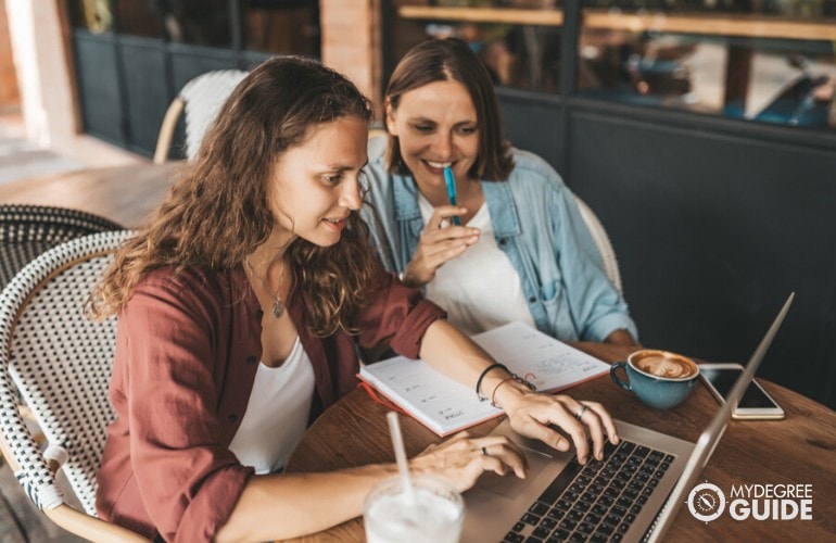 Business degree students studying together in a cafe