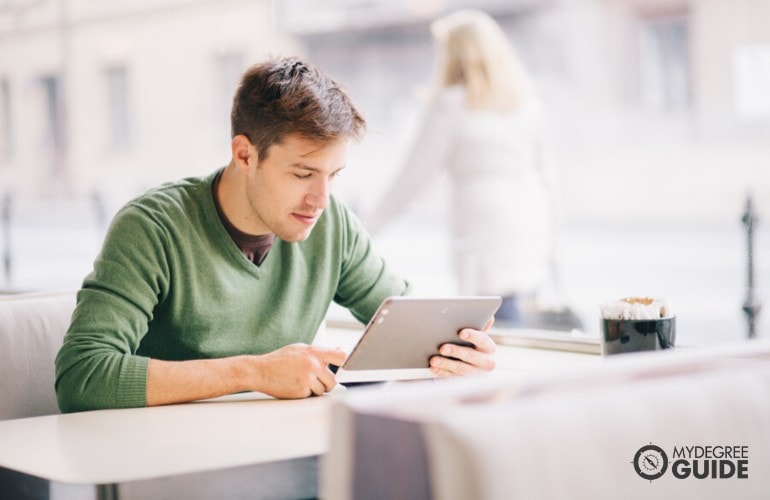 Communications Degree student studying online in a cafe