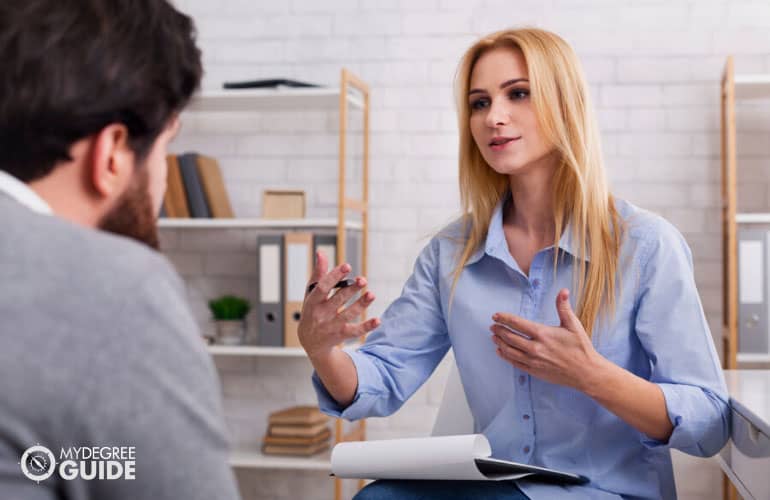 female counselor giving advice to a patient during counseling session in her office