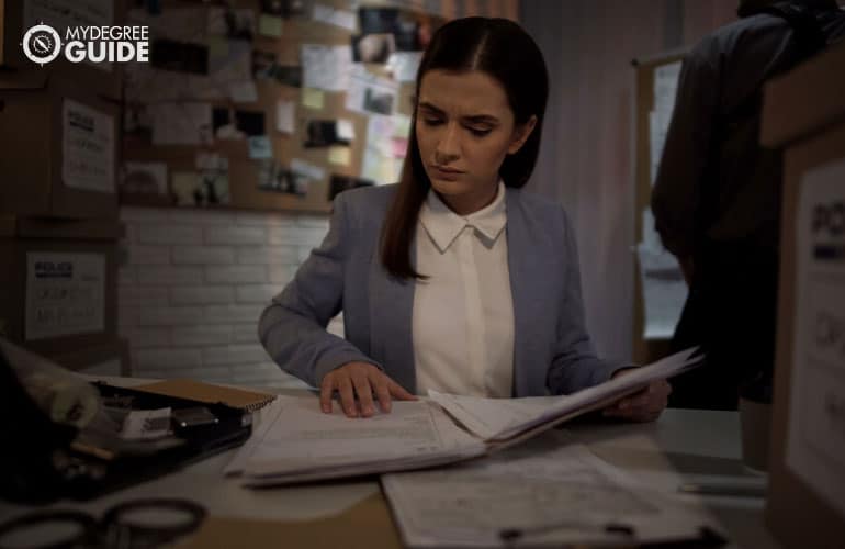 female cop examining findings for a crime in her office