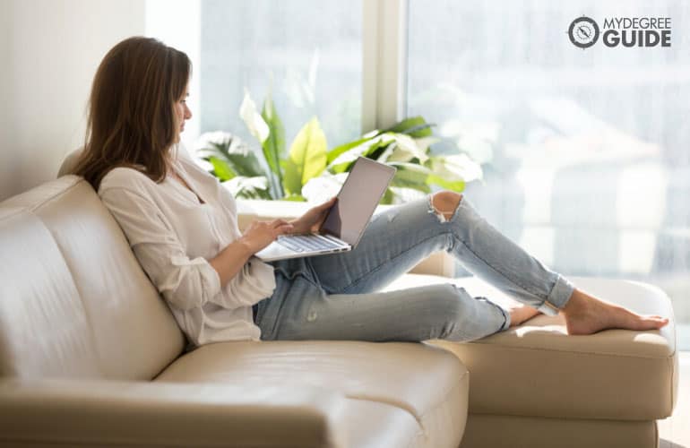 human services degree student studying comfortably on her laptop