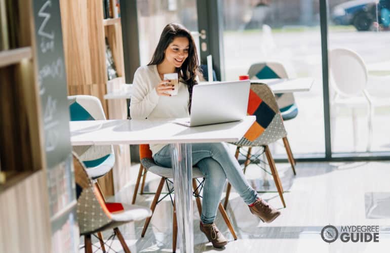 student in a café working on her laptop