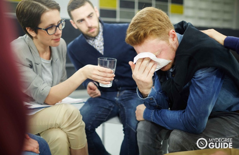 counselor comforting a patient during group therapy session