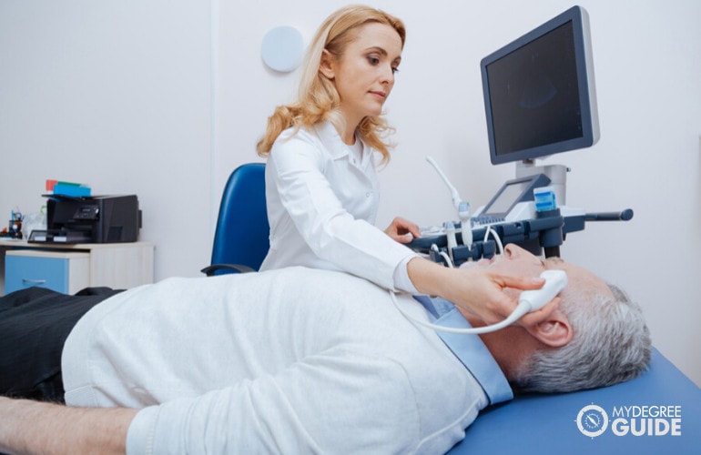 Diagnostic medical sonographer checking a patient