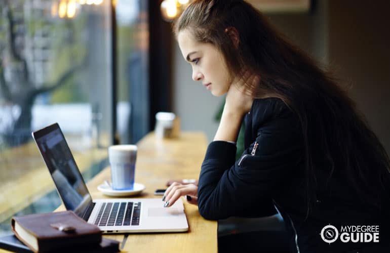 student browsing a college catalog on her laptop