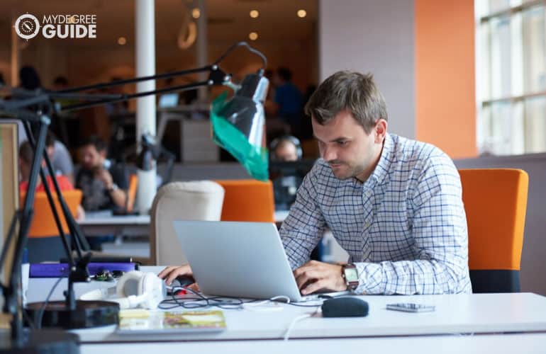 software developer working on his computer at a modern office