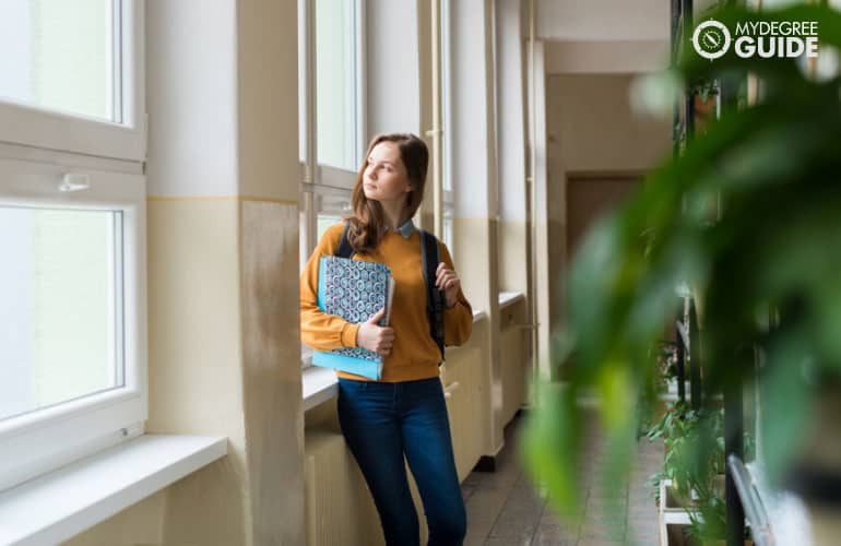 student standing in hallway thinking