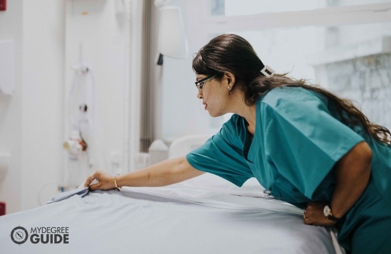 nurse fixing a patient's bed