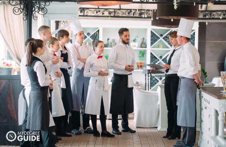 restaurant manager meeting with the employees before opening the restaurant