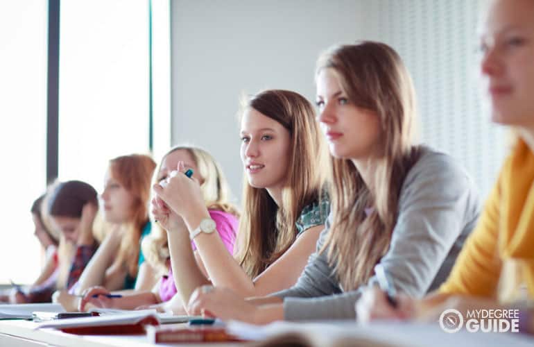 students listening to a professor in university classroom