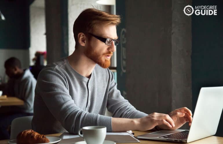 bachelor's degree student studying online in a coffee shop