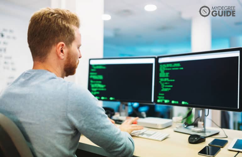 male developer working on his computer in an office