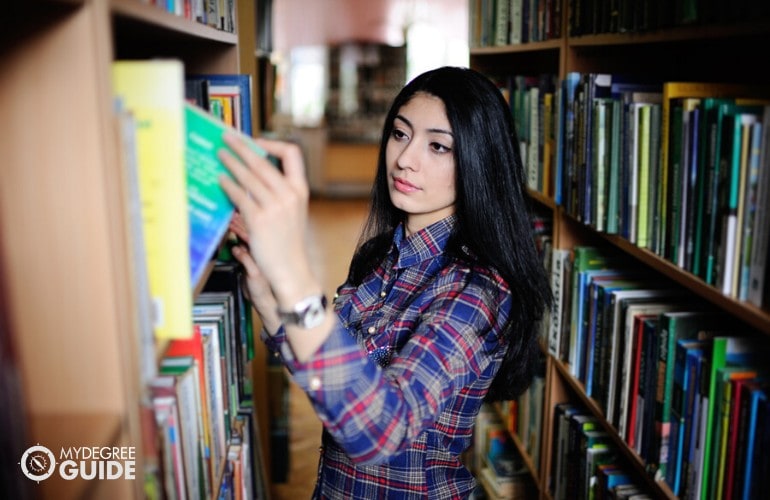 Bachelor's in History student searching for a book in library