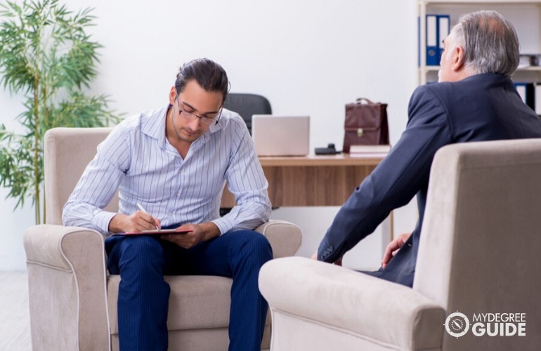 psychologist writing his notes during a therapy session