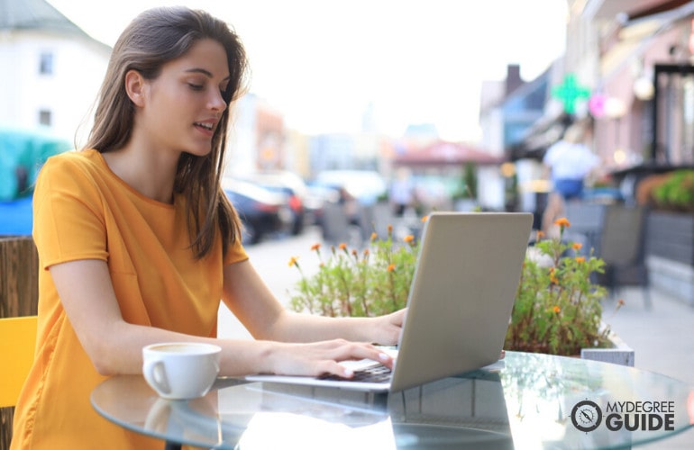 Behavior Analyst degree graduate working on her laptop in a cafe