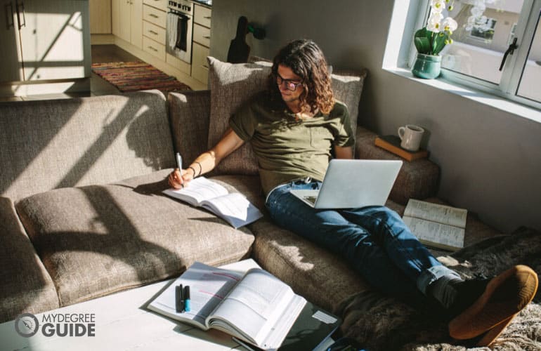 student studying comfortably on his laptop 