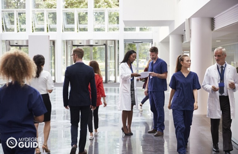 medical administrator talking to hospital staff in hallway