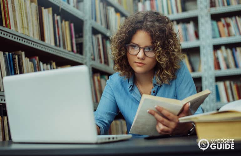 DBA student working on her laptop in a university library