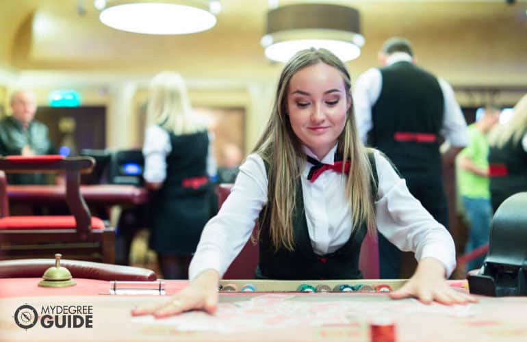 casino worker fixing cards on a poker table