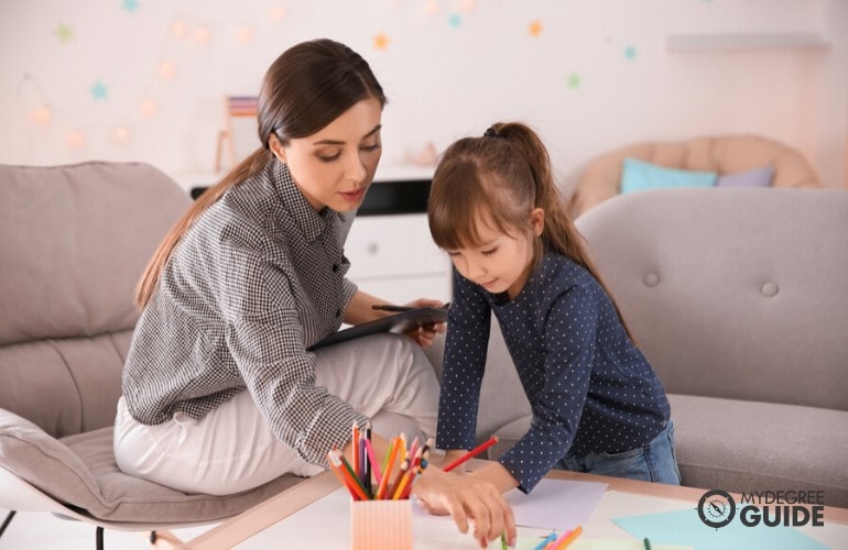 educational psychologists teaching a child how to write