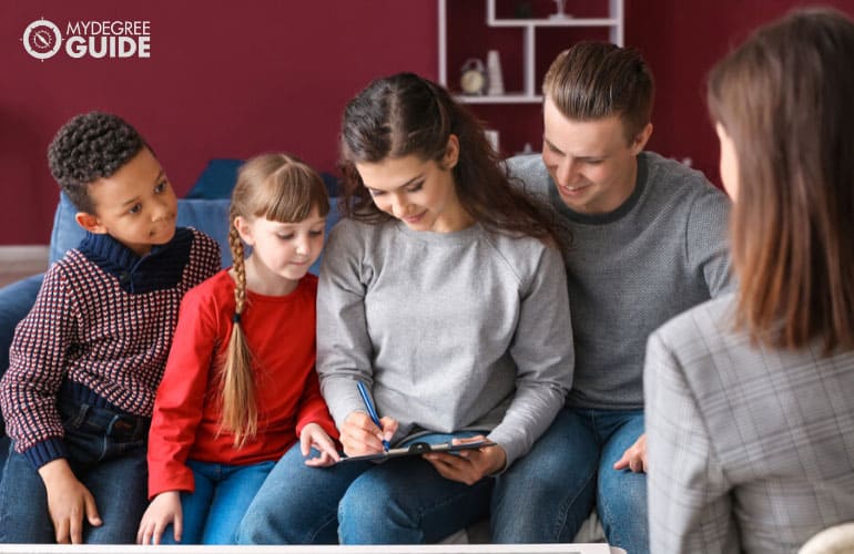 family in a counselor's office filling up some documents