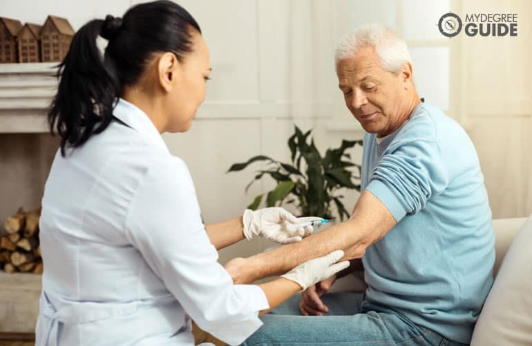 doctor injecting a vaccine to a patient in a senior home