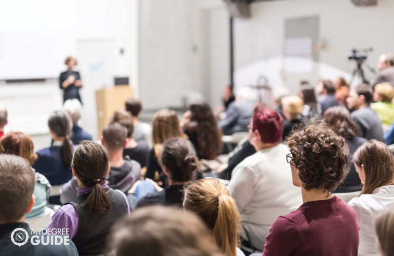 university students listening to a speaker during a conference on drug prevention