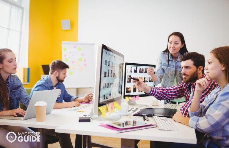 team of computer animators working together in a modern office