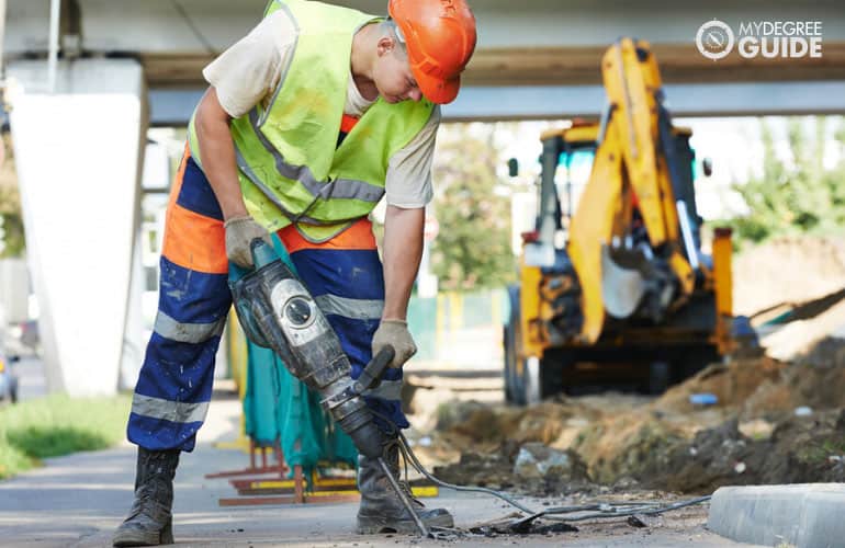 worker drilling in a construction site