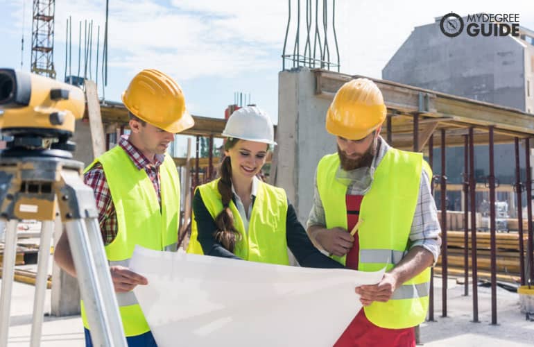 construction managers looking on blueprint at a construction site