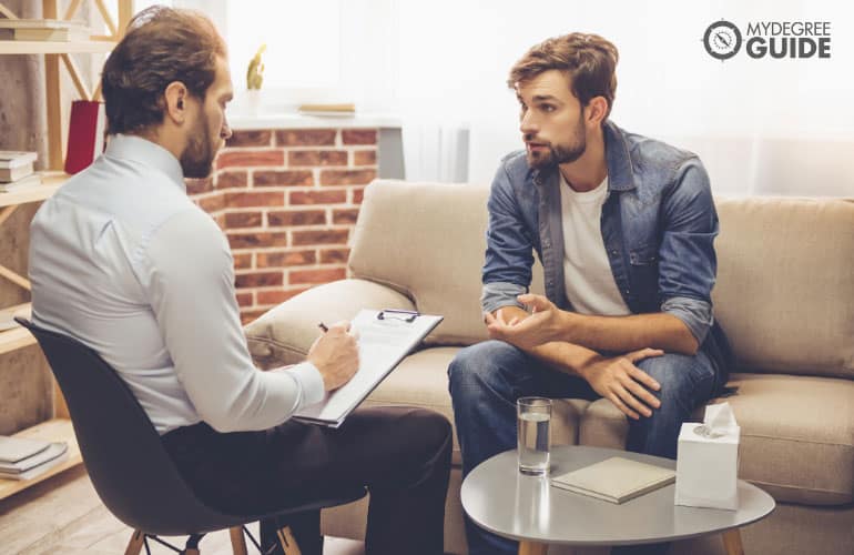 male counselor listening to a patient during counseling