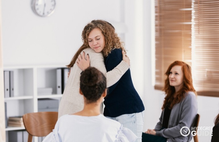 counselor comforting a patient during group therapy