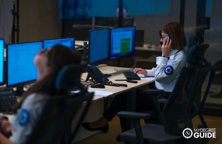 security personnel monitoring CCTV cameras in surveillance room