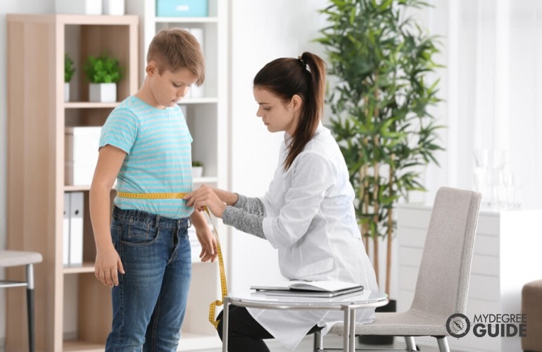 dietitian taking measurement of a young patient