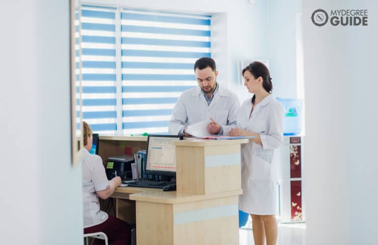 nurse and doctor discussing in hospital lobby