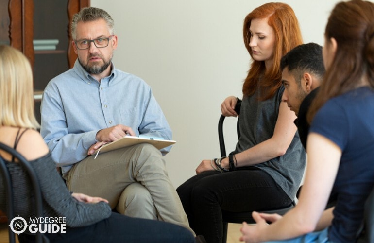 psychiatrist listening to patients during group counseling 