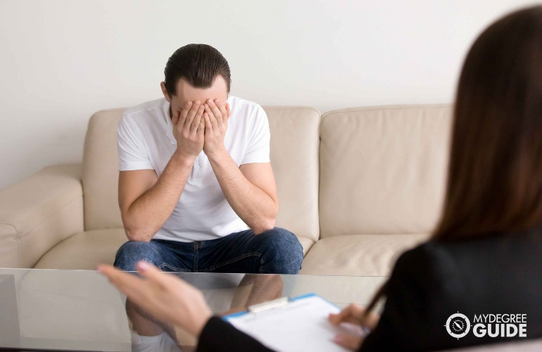 counselor talking to her sad patient in her rehab clinic