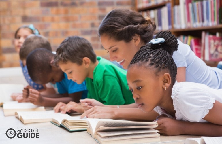 Early Childhood Education teacher helping her students in reading