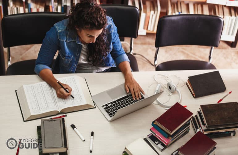 student studying on her computer in a college library