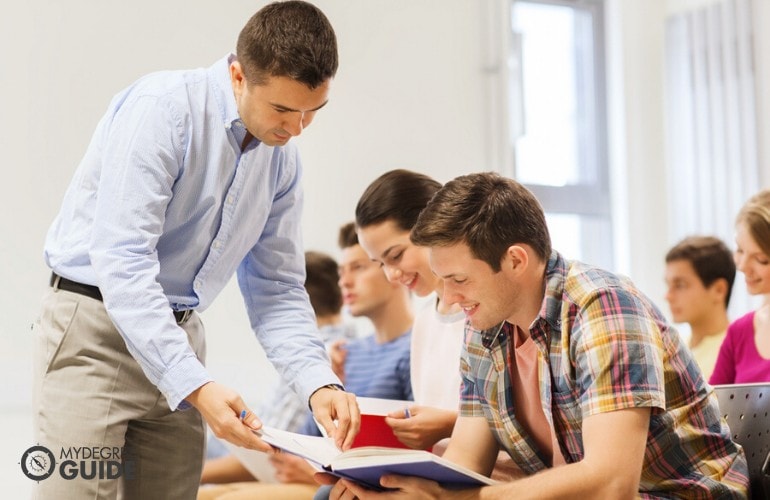 college teacher assisting his students in class