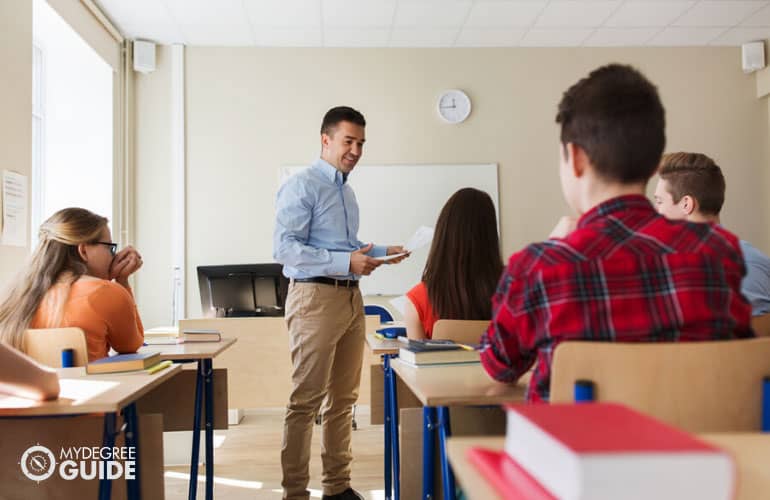 high school teacher teaching students in a classroom