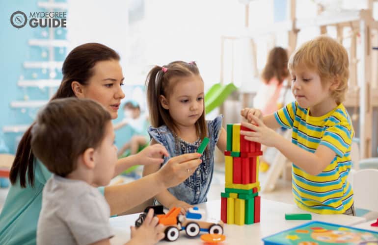 preschool teacher assisting the kids during playtime