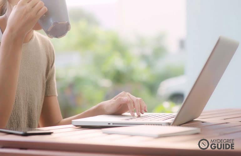 female author writing while drinking coffee