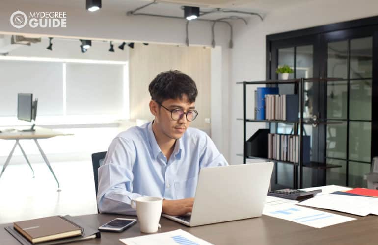 male operations manager working on his laptop