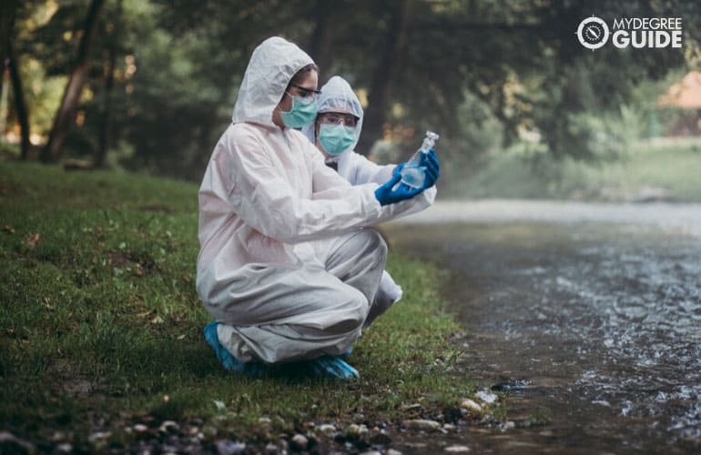 Environmental Health scientists taking samples of water in a river