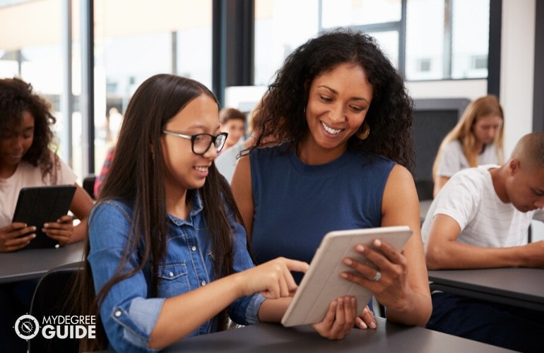 high school teacher assisting her students in class