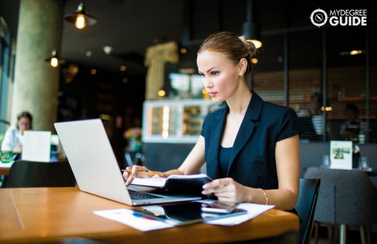 financial manager working on her laptop in a cafe