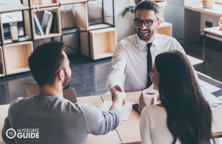 financial advisor closing a deal to a young couple