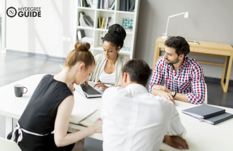 office administrator having a meeting with her team in a conference room