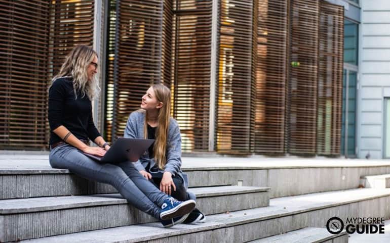 two women talking on college campus